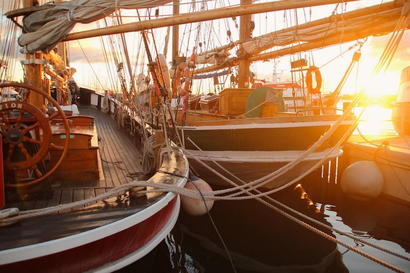 Sonnenuntergang zwischen Booten am Hafen